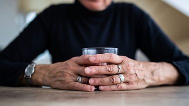 Ältere Dame hält sich an einem Glas Alkohol fest - Foto: miodrag_ignjatovic / iStock