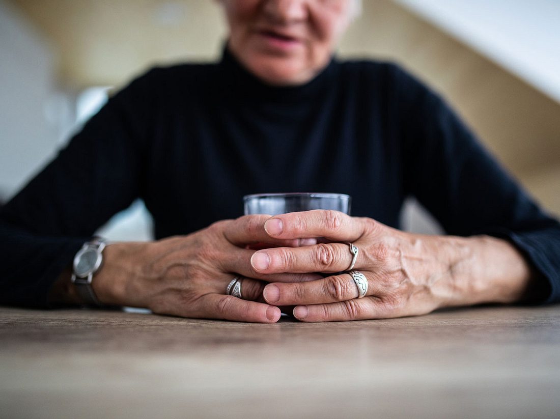 Ältere Dame hält sich an einem Glas Alkohol fest Ältere Dame hält sich an einem Glas Alkohol fest