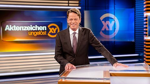 Moderator Rudi Cerne steht im Studio und lacht in die Kamera. - Foto: ZDF / Nadine Rupp