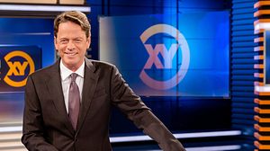 Moderator Rudi Cerne steht im Aktenzeichen XY-Studio und lacht in die Kamera. - Foto: ZDF / Nadine Rupp