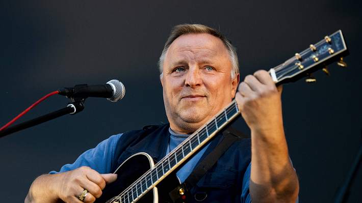 Axel Prahl mit Gitarre und Mikrofon - Foto: IMAGO / Robert Michael