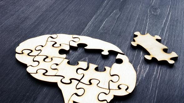 Holzpuzzle, das aussieht wie ein Gehirn dem Teile fehlen.  - Foto: designer491 / iStock