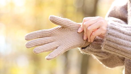 Beheizbare Handschuhe an einer Frauenhand - Foto: iStock/AntonioGuillem