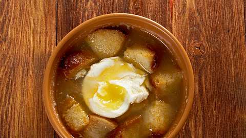 Die Sopa de ajo ist eine klassische Knoblauch-Brot-Suppe mit pochiertem Ei. - Foto: MychkoAlezander / iStock