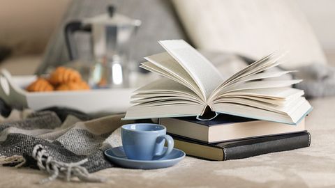 Bücher und Kaffeetasse auf Bett - Foto: iStock/Oleh_photographer