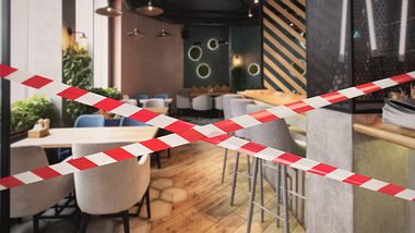 Der Sitzbereich eines Cafés ist mit Flatterband abgesperrt worden. - Foto: iStock / Prostock-Studio