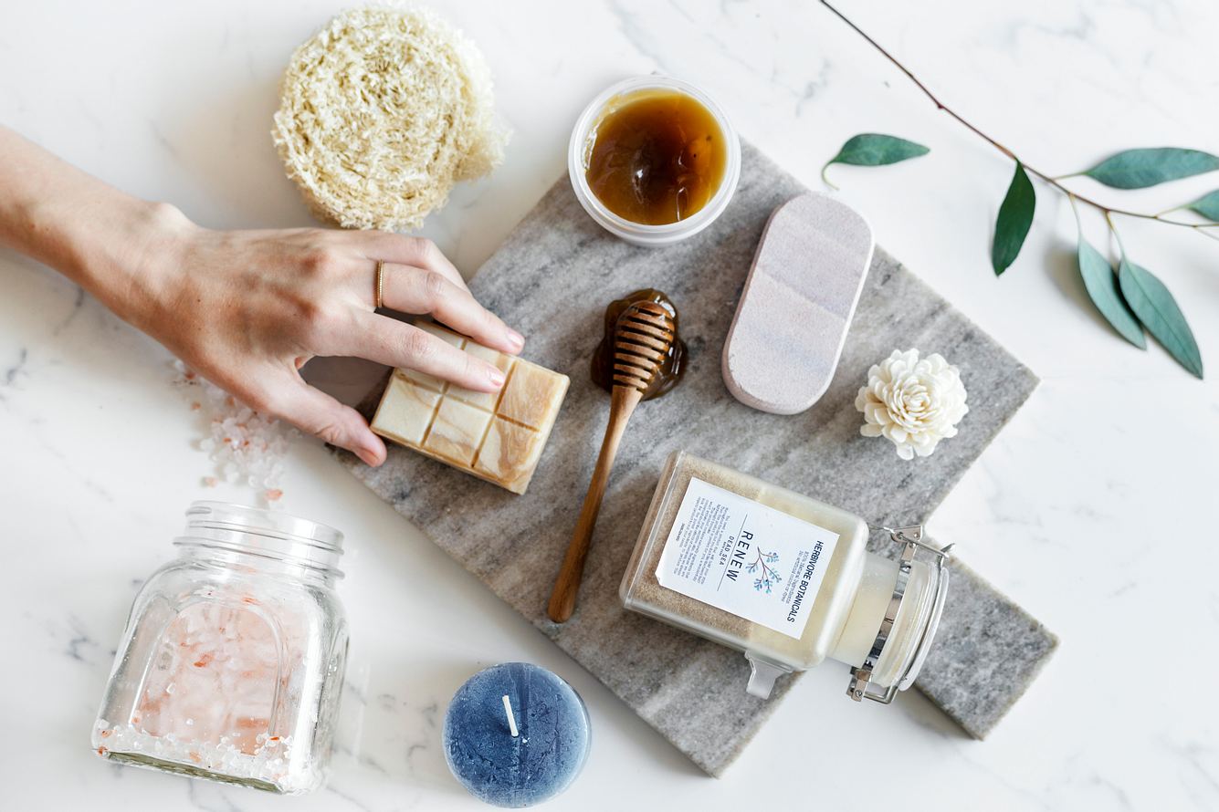 Verschiedene nachhaltige Clean Beauty-Produkte vor hellgrauem Hintergrund