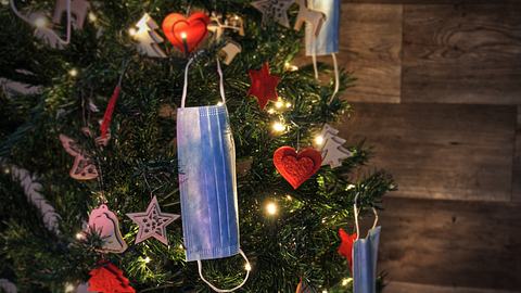 Ein Weihnachtsbaum mit weihnachtlicher Dekoration und Corona-Schutzmasken geschmückt. - Foto: Margarita Monge Ortega / iStock