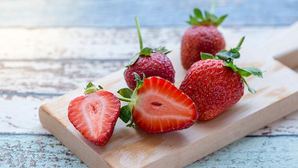 Erdbeeren auf einem Holzbrett.  - Foto: Muratani / iStock