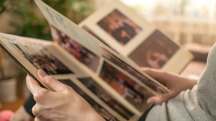 Frau blättert in Fotoalbum - Foto: iStock/Olga Ihnatsyeva