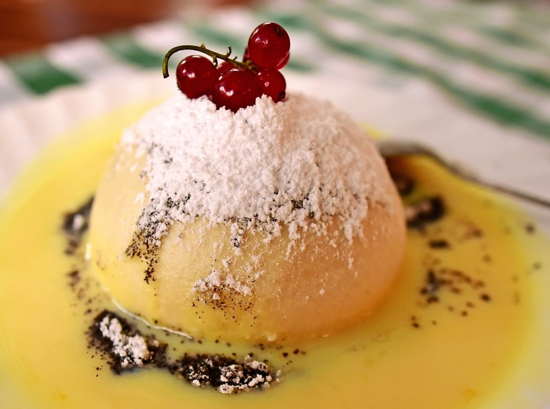 Germknödel mit Vanillesoße und dekoriert mit Johannisbeeren. Germknödel mit Vanillesoße und dekoriert mit Johannisbeeren.