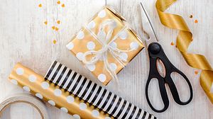 Verpacktes Geschenk, Geschenkpapierrollen und Schere