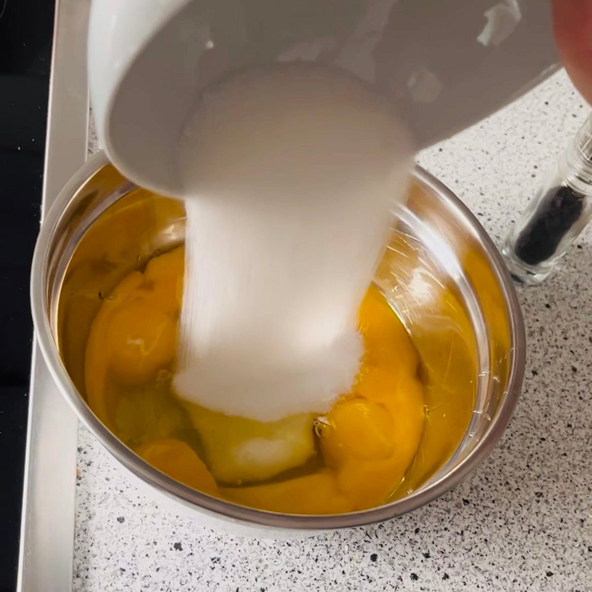 Schritt 2: Eigelb in eine Schüssel geben und mit zwei Eiweiß, Zucker und Vanillemark verrühren.