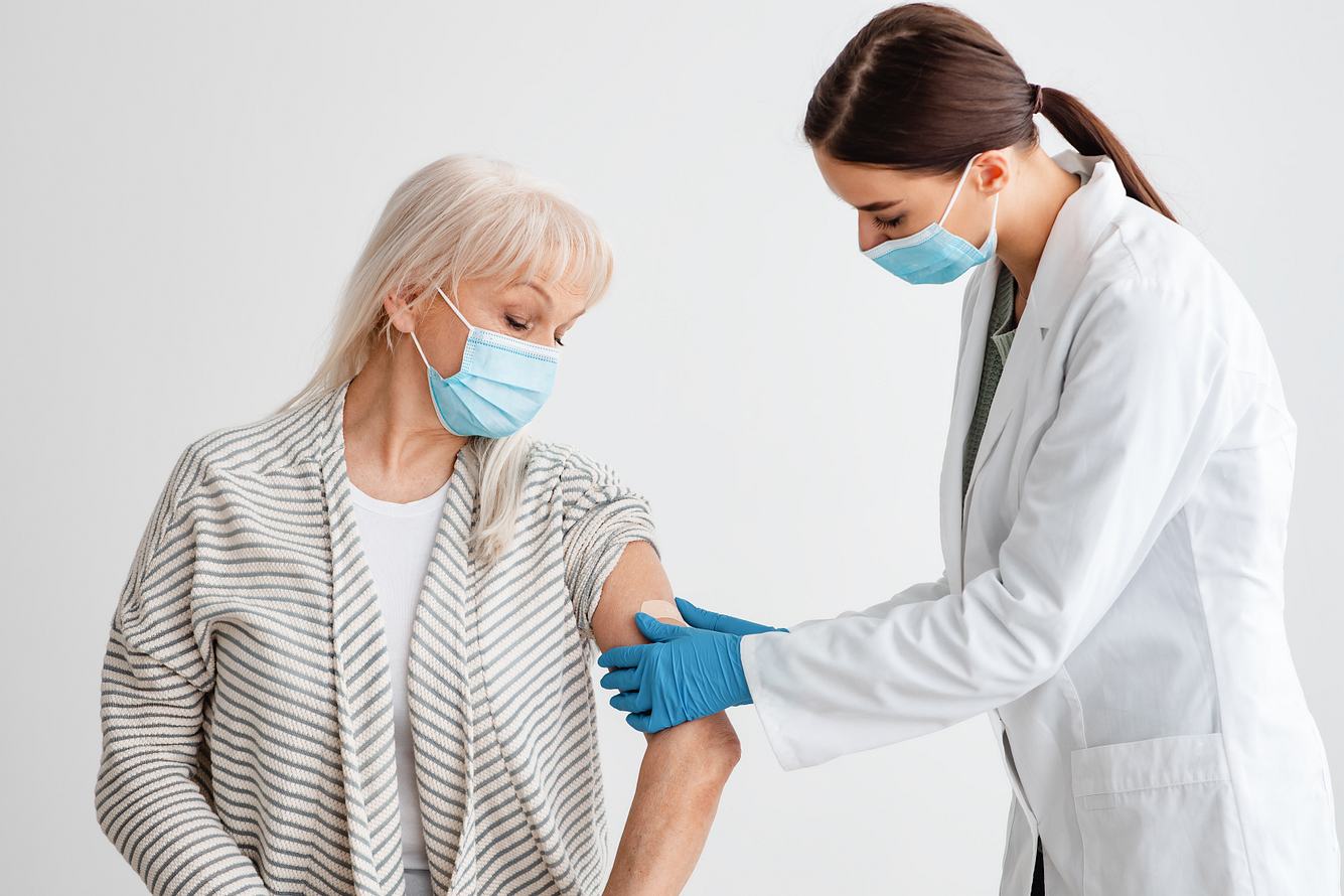 Eine ältere Frau wird im Arm geimpft.
