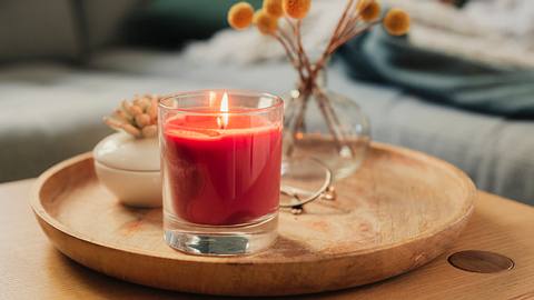 Rote Kerze im Glas auf einem Holztablett - Foto: iStock/knape