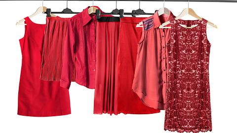 Rote Kleidungsstücke auf einer Kleiderstange. 