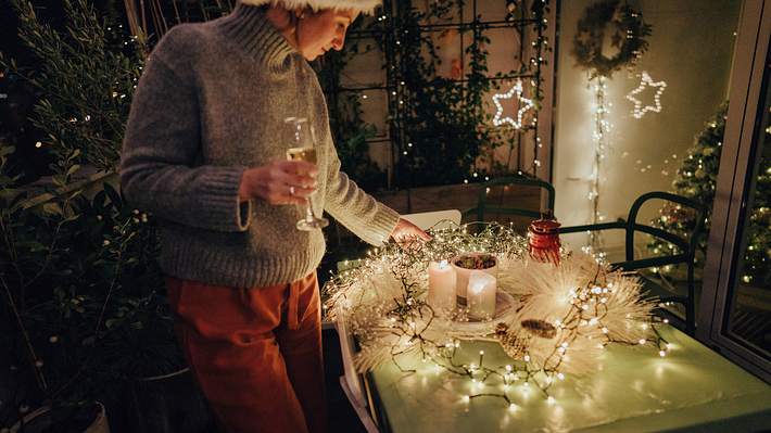 Frau mit Lichterkette - Foto: iStock/AleksandarNakic