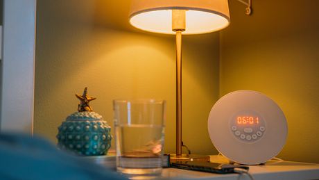 Ein Lichtwecker steht in einem Schlafzimmer auf dem Nachttisch. - Foto: iStock/ knape