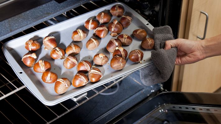 Maronen auf einem Backblech werden im Backofen geröstet. - Foto: patrickheagney / iStock