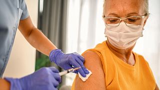 Eine Frau wird geimpft. - Foto: iStock / bluecinema