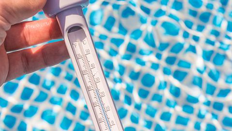 Wassertemperatur wird mit einem Pool Thermometer gemessen. - Foto: iStock/ Ralf Geithe
