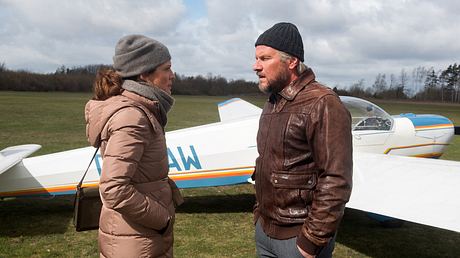 Tatjana und Jens stehen vor einem Flugzeug.  - Foto: ARD / Nicole Manthey