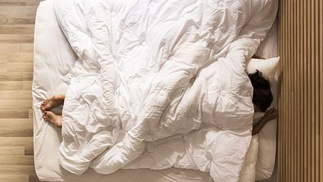 Schneller einschlafen: Eine Gewichtsdecke kann helfen - Foto: kizilkayaphotos / iStock