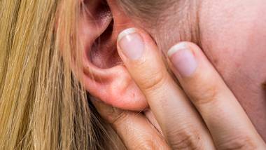 Frau hält sich ihr Ohr.  - Foto: Animaflora / iStock