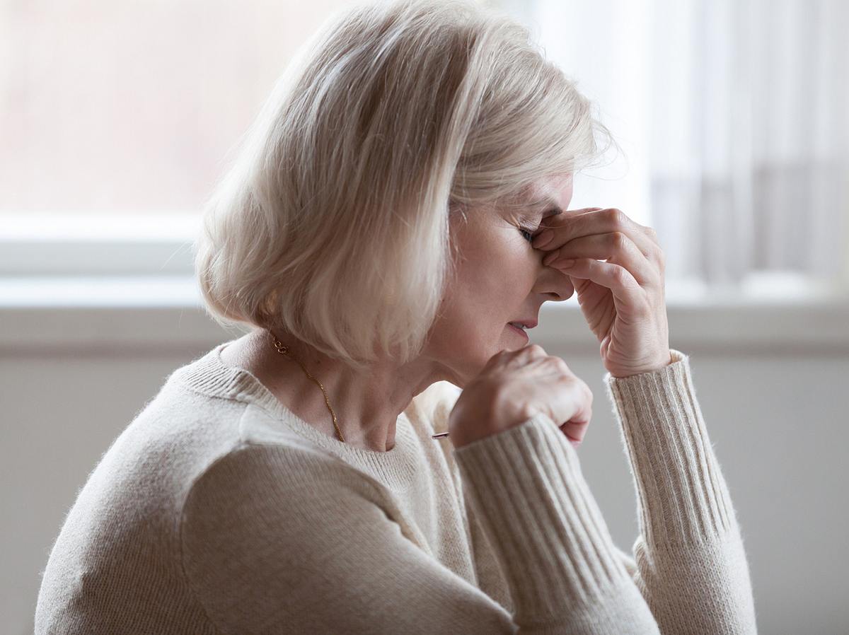 Eine Frau mittleren Alters leidet an Kopfschmerzen