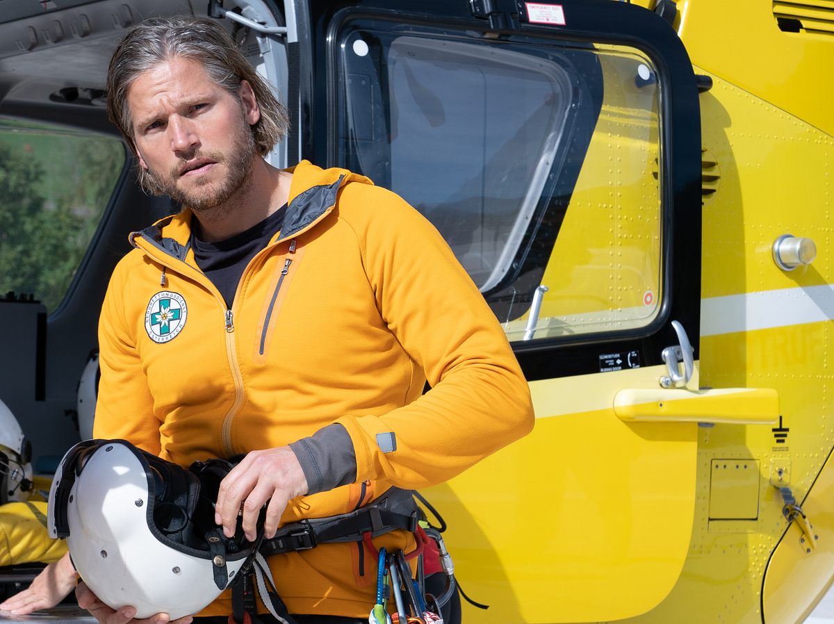Sebastian Ströbel als Markus Kofler vor dem gelben 'Bergretter'-Hubschrauber