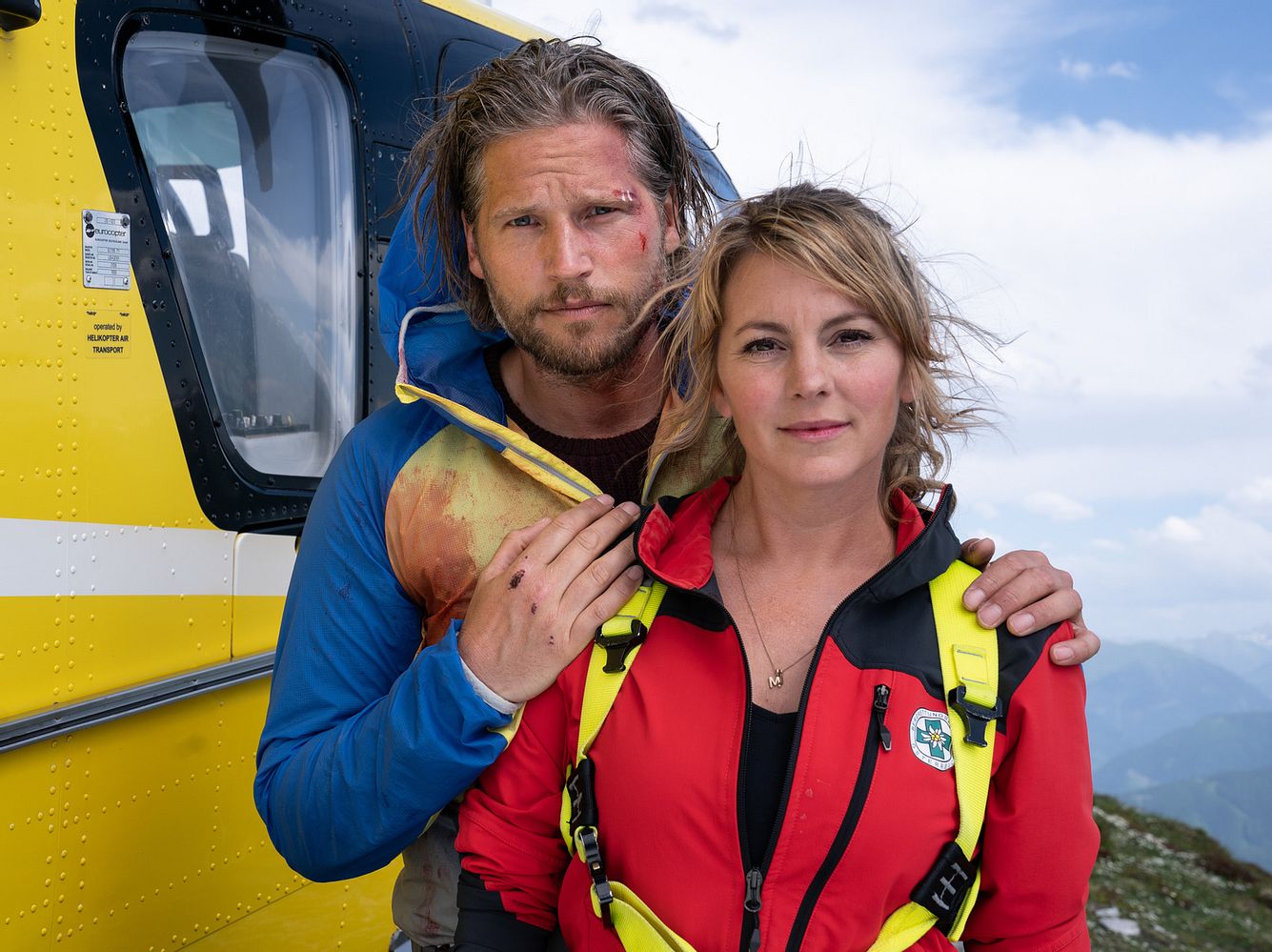 Sebastian Ströbel als Markus und Luise Bähr als Katharina vor dem 'Bergretter'-Hubschrauber