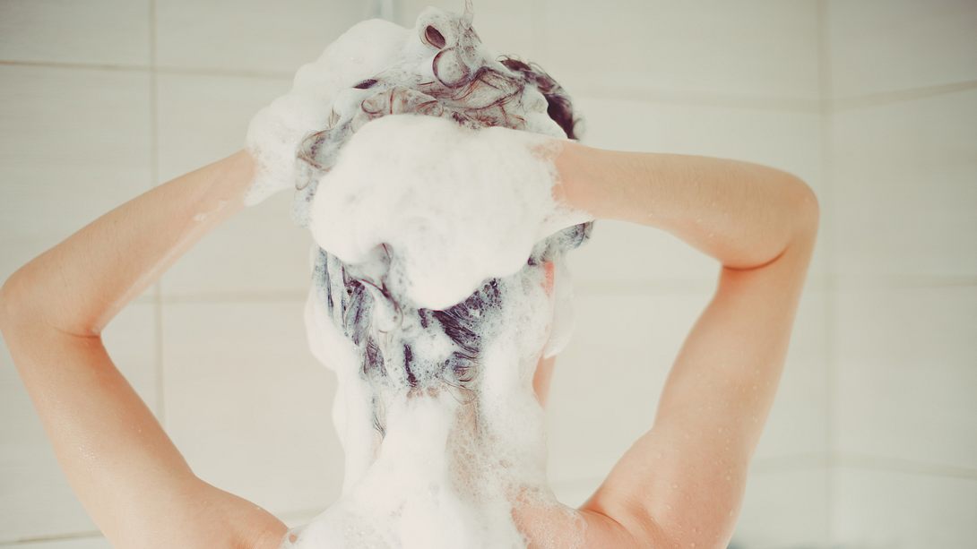 Frau wäscht sich die Haare mit einem Shampoo gegen Haarausfall - Foto: iStock/Alina Rosanova