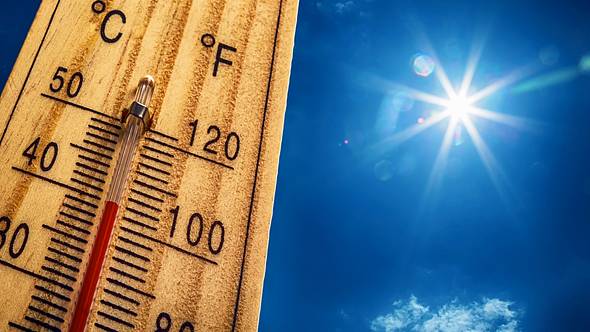 Ein hölzernes Thermometer zeigt vor blauem Himmel hohe Temperaturen an. - Foto: iStock / MarianVejcik