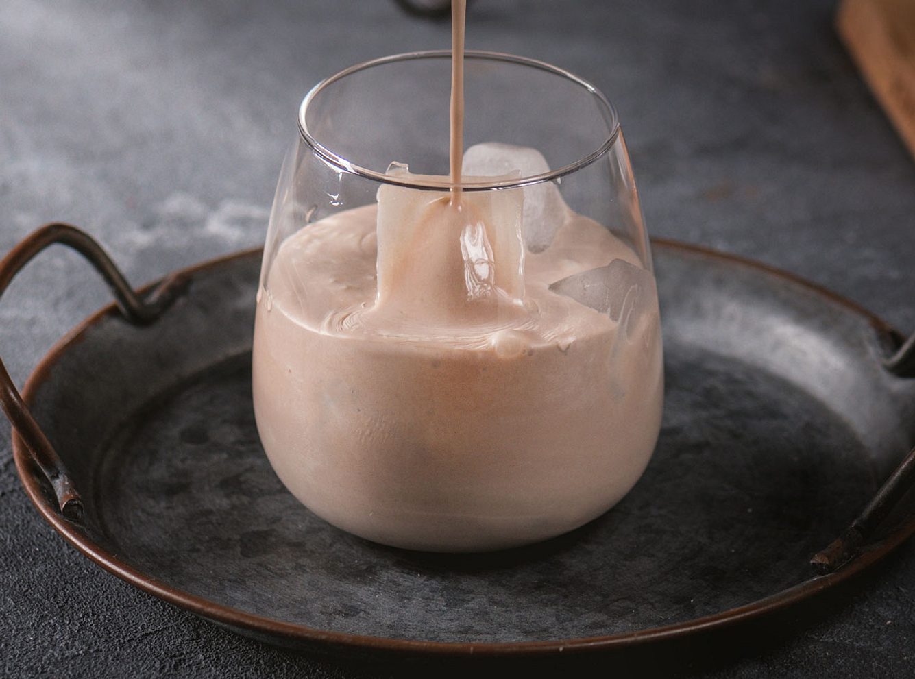 In eine Glas mit Eis wird Spekulatius-Likör eingeschenkt. In eine Glas mit Eis wird Spekulatius-Likör eingeschenkt.