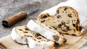 Ein angeschnittener Stollen auf eine Jutetuch, daneben liegt ein Küchenmesser.  - Foto: etorres69 / iStock