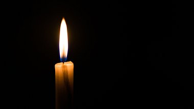 Eine brennende Kerze im Dunkeln.  - Foto: Aleksandr_Vorobev / iStock