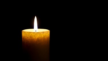 Eine brennende Kerze in Gedenken an prominente Todesfälle im Jahr 2022 - Foto: fcafotodigital / iStock