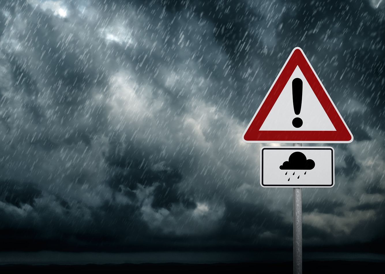 Starkregen und Gewitter begleiten Start ins Wochenende. Ein Verkehrsschild warnt vor Unwettern.