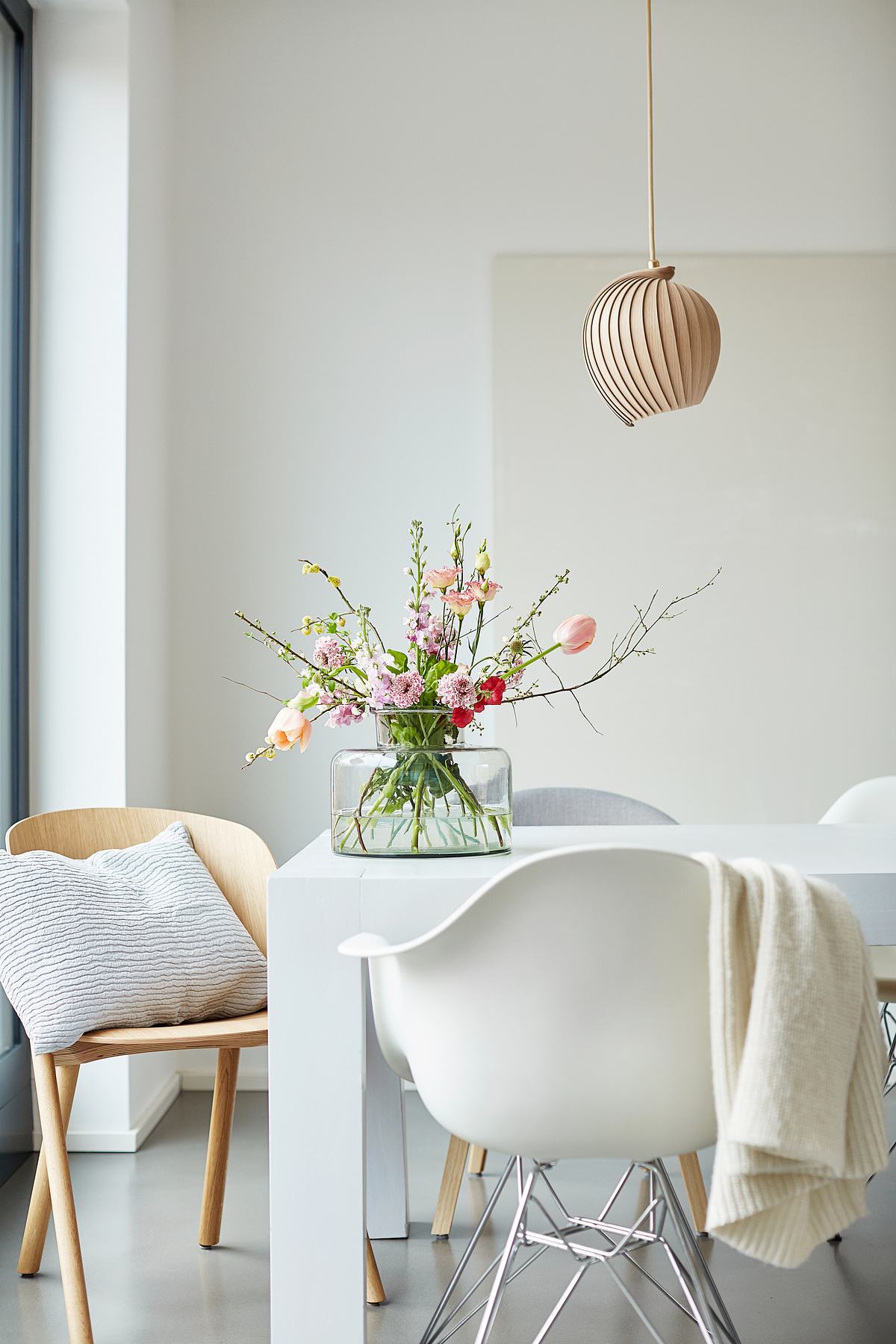 Vase befüllt mit Blumen steht auf einem Tisch.