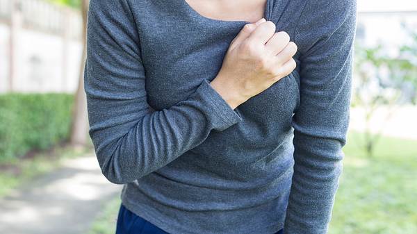 Frau hat Herzprobleme und fasst sich an die Brust - Foto: champja / iStock