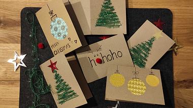 Gebastelte Weihnachtskarten auf einem Holztisch. - Foto: Liebenswert