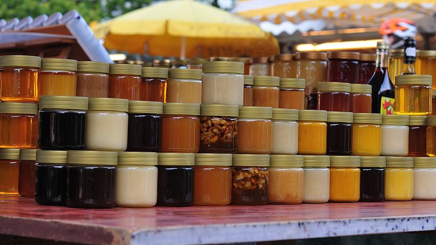 Verschiedene Honigsorten an einem Marktstand.